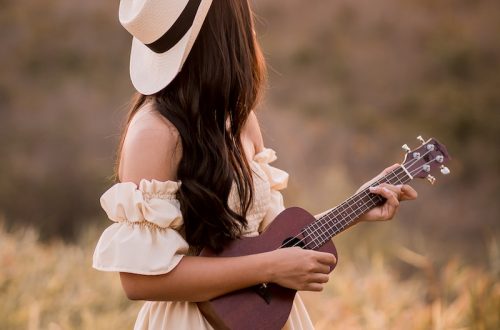 woman in white dress playing acoustic guitar